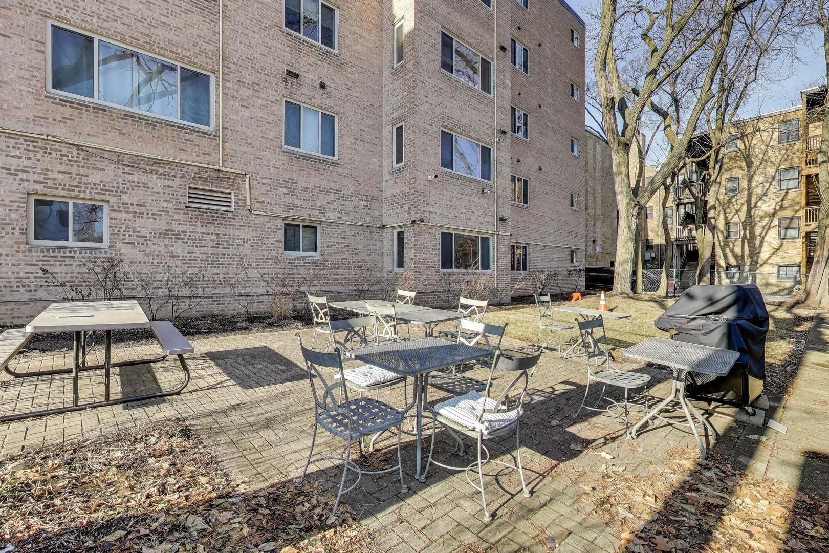 835 Ridge Avenue, Unit 205 Evanston, IL 60202 - Photo 17 of 18 a view of a patio with couches table and chairs under an umbrella