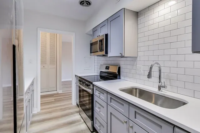 a kitchen with stainless steel appliances granite countertop a sink and a stove