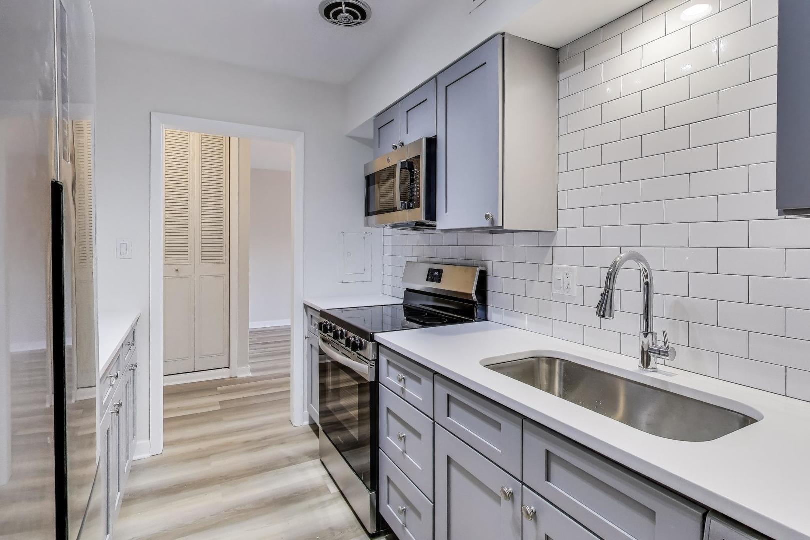 835 Ridge Avenue, Unit 205 Evanston, IL 60202 - Photo 7 of 18 a kitchen with stainless steel appliances granite countertop a sink and a stove