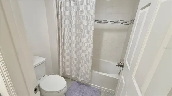 a white toilet sitting next to a shower