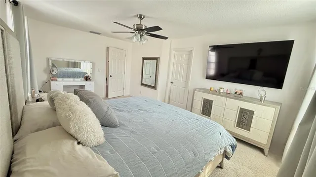 a spacious bedroom with a bed and a flat screen tv