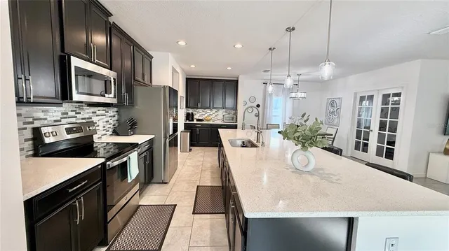 a large kitchen with granite countertop a large counter top appliances and cabinets