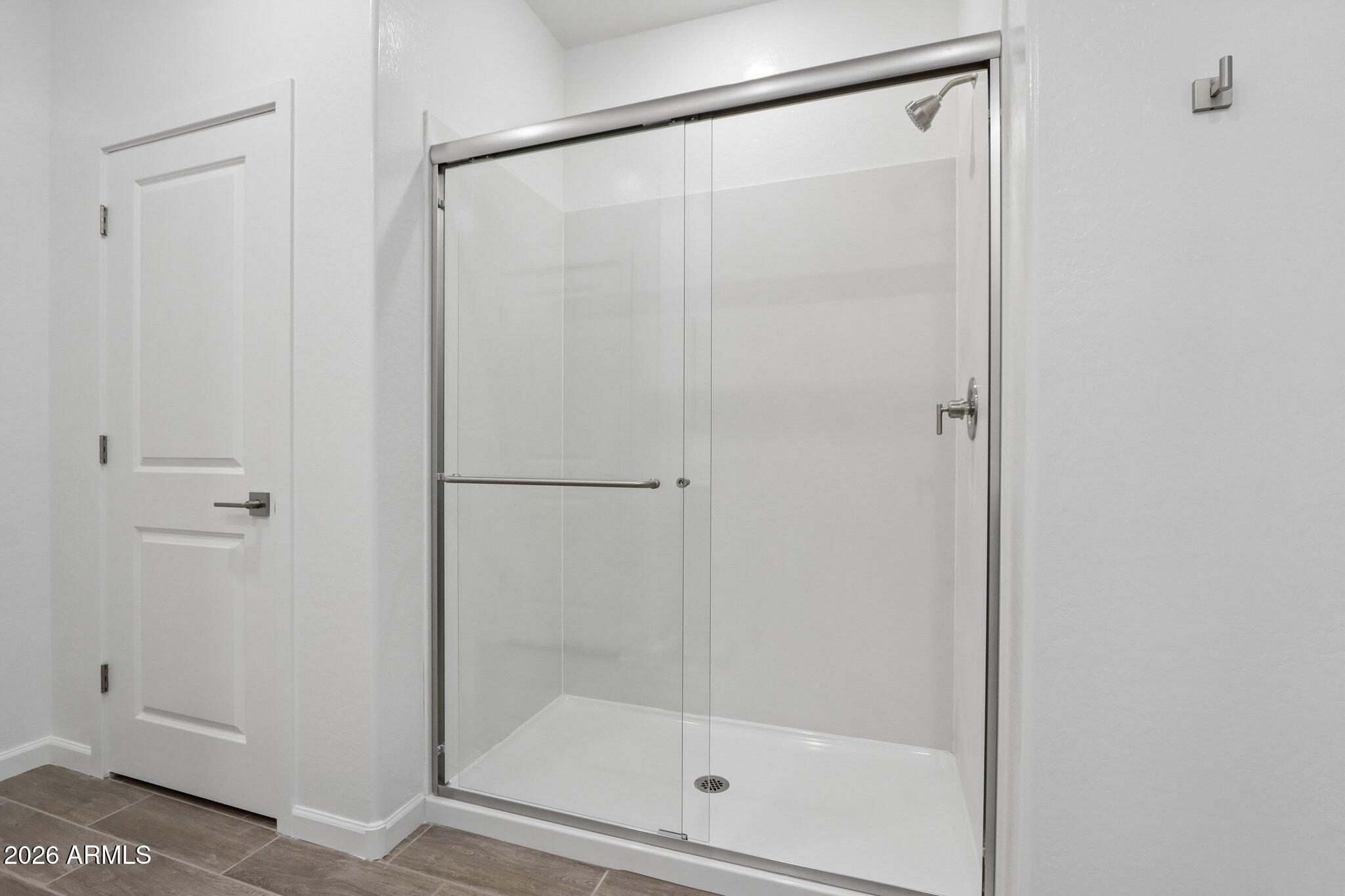 9544 West Gaby Road Tolleson, AZ 85353 - Photo 15 of 43 a bathroom with a glass shower door