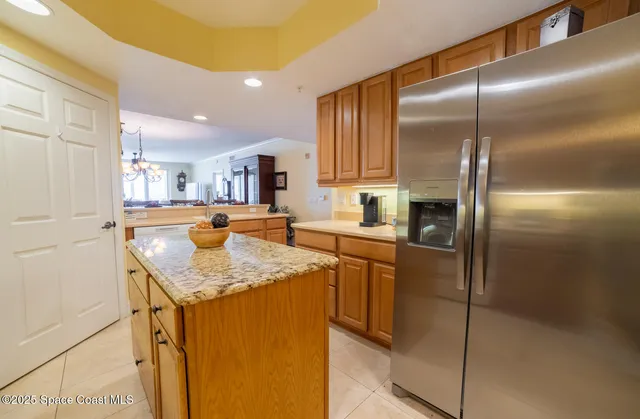 a kitchen with kitchen island granite countertop cabinets and refrigerator