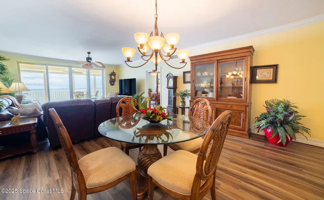 a dining room with furniture a chandelier and wooden floor