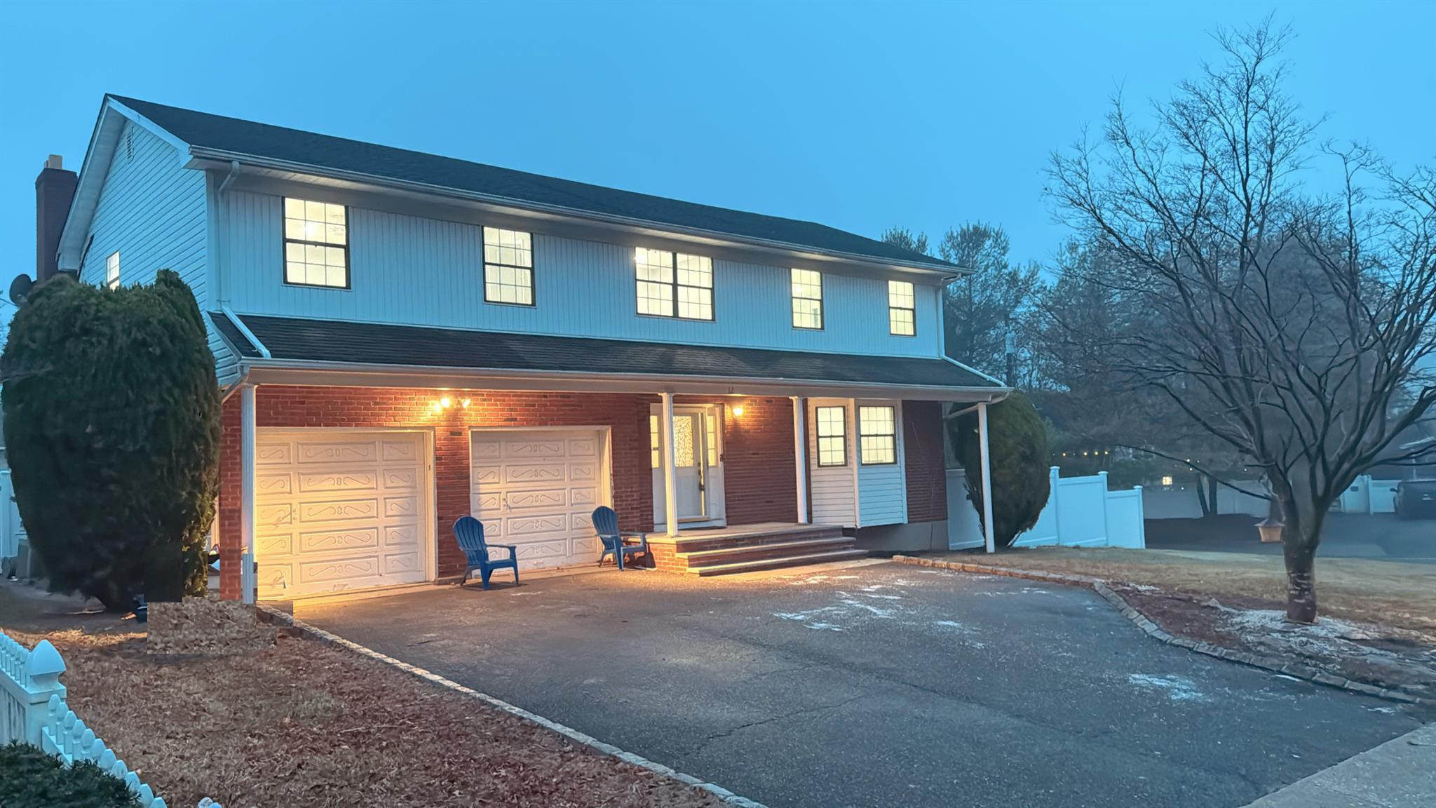 12 Battle Road Old Bethpage, NY 11804 - Photo 1 of 1 View of front facade with aphalt driveway, covered porch, brick siding, and a garage