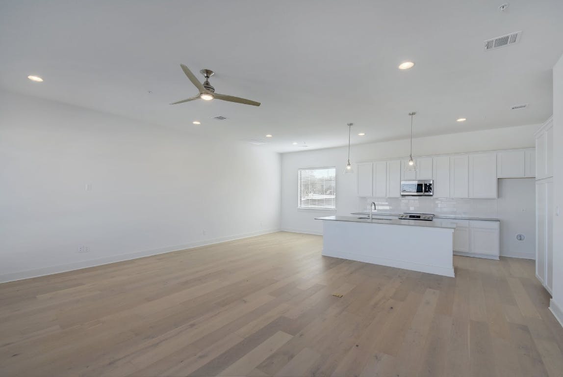 2050 Lohmans Spur Road, Unit 402 Austin, TX 78734 - Photo 13 of 39 a large kitchen with kitchen island a sink dishwasher a stove and a refrigerator with wooden floor