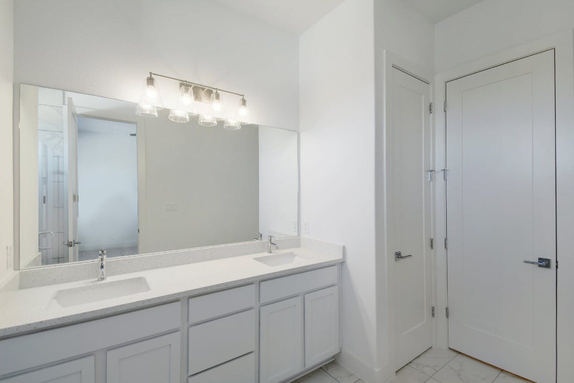 2050 Lohmans Spur Road, Unit 402 Austin, TX 78734 - Photo 22 of 39 a bathroom with double vanity sink and a mirror