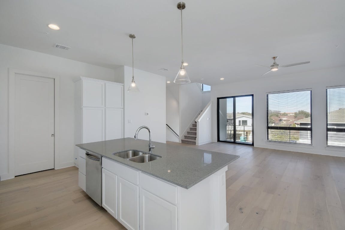 2050 Lohmans Spur Road, Unit 402 Austin, TX 78734 - Photo 5 of 39 a kitchen with stainless steel appliances granite countertop a sink a oven and a large window