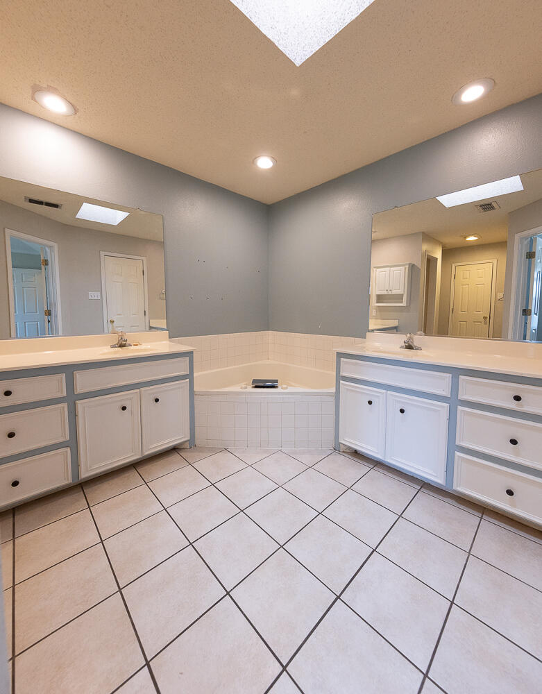 2923 85th Street Lubbock, TX 79423 - Photo 15 of 23 a spacious bathroom with a double vanity sink mirror and bathtub