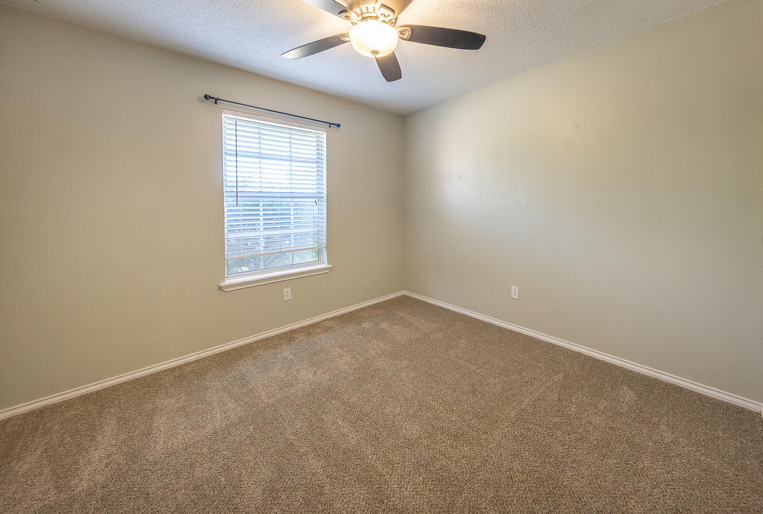 2923 85th Street Lubbock, TX 79423 - Photo 17 of 23 an empty room with a window and a fan