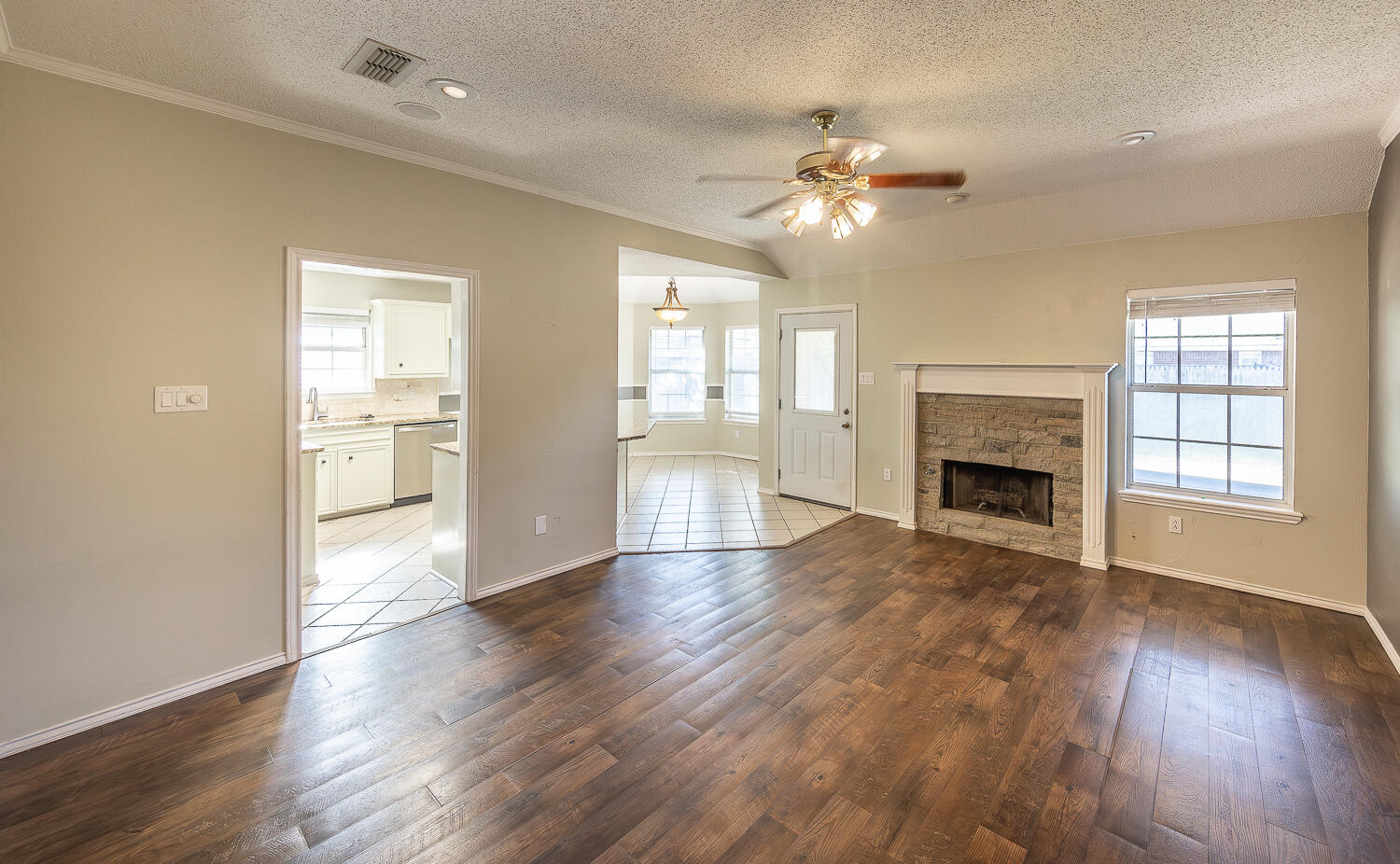 2923 85th Street Lubbock, TX 79423 - Photo 3 of 23 an empty room with wooden floor fireplace and windows