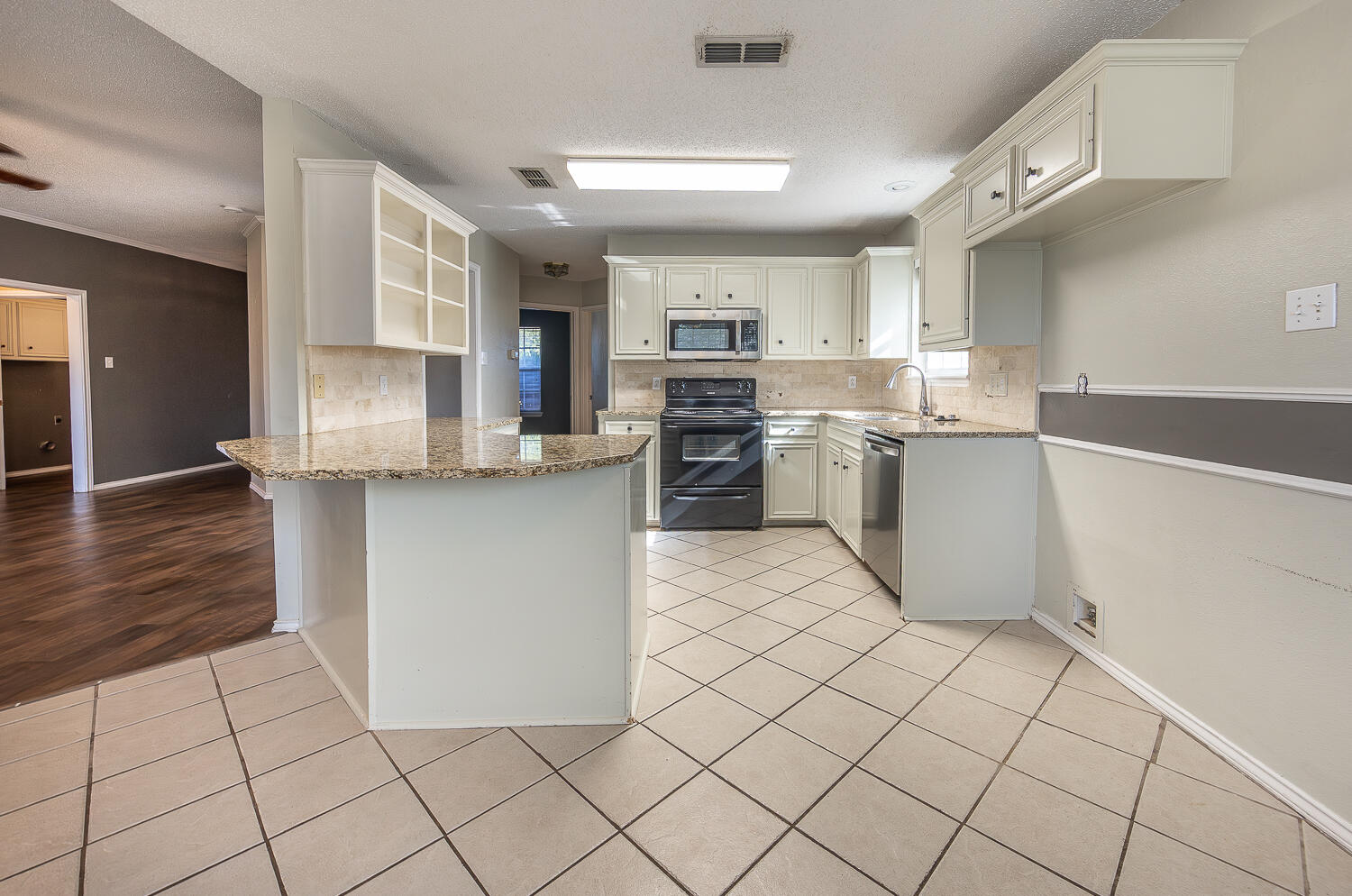 2923 85th Street Lubbock, TX 79423 - Photo 10 of 23 a kitchen with stainless steel appliances granite countertop a refrigerator sink and cabinets
