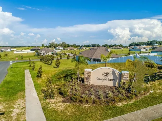 an aerial view of a house with outdoor space and lake view in back