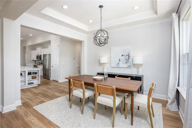 a kitchen with stainless steel appliances kitchen island granite countertop a stove a sink and a refrigerator with wooden floor