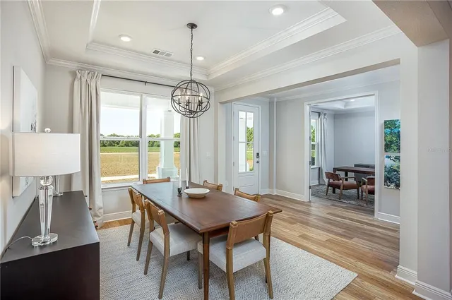 a living room with couches and kitchen view with wooden floor