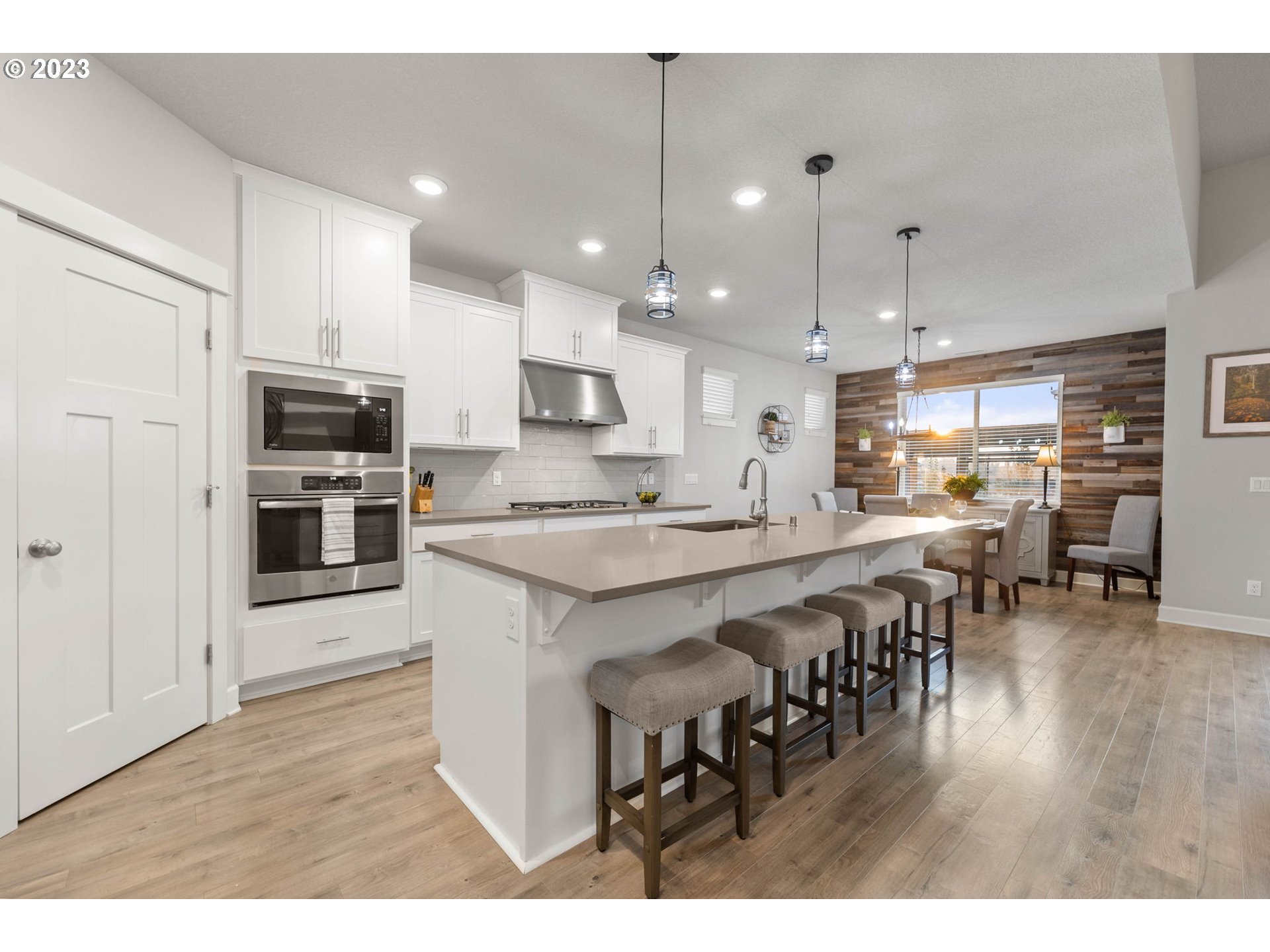 1851 South 47th Place Ridgefield, WA 98642 - Photo 4 of 31 a large kitchen with kitchen island a dining table chairs and a refrigerator