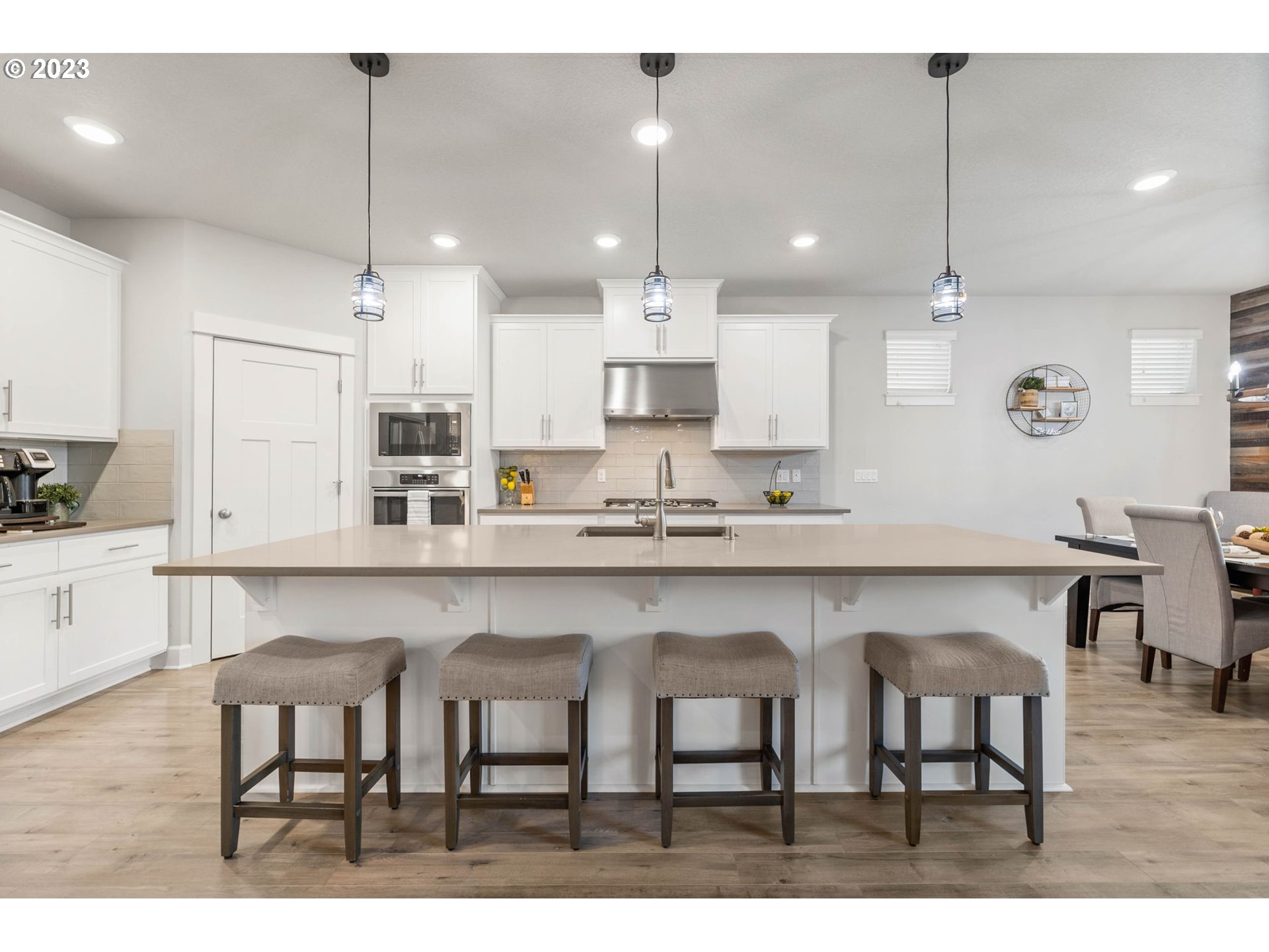 1851 South 47th Place Ridgefield, WA 98642 - Photo 5 of 31 a kitchen with kitchen island granite countertop a table chairs refrigerator and microwave