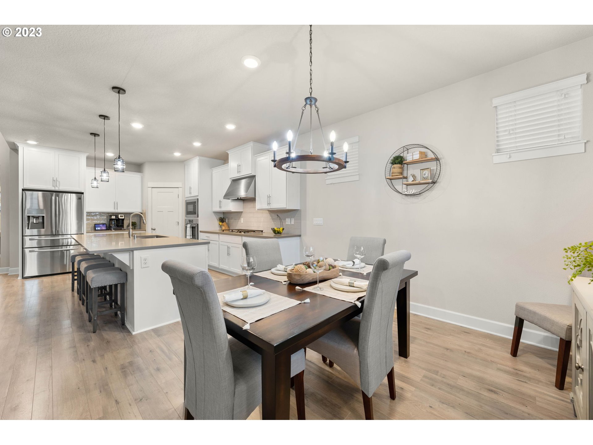 1851 South 47th Place Ridgefield, WA 98642 - Photo 6 of 31 a dining room with wooden floor a chandelier a wooden table and chairs