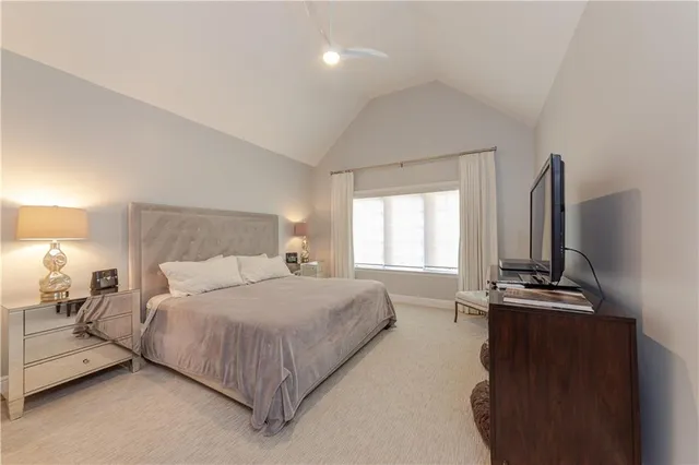 a bedroom with a bed and a flat tv screen on dresser