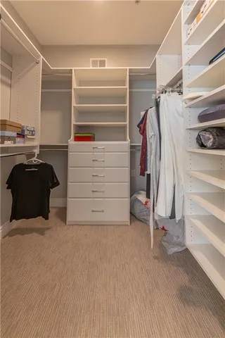a view of walk in closet with clothes and shoes
