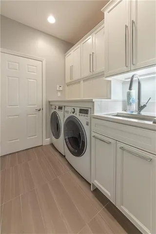 a utility room with sink dryer and washer