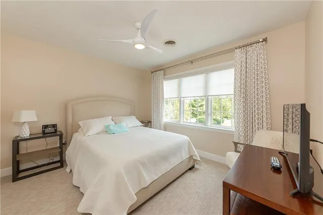 a bedroom with a bed and a flat tv screen on a dresser