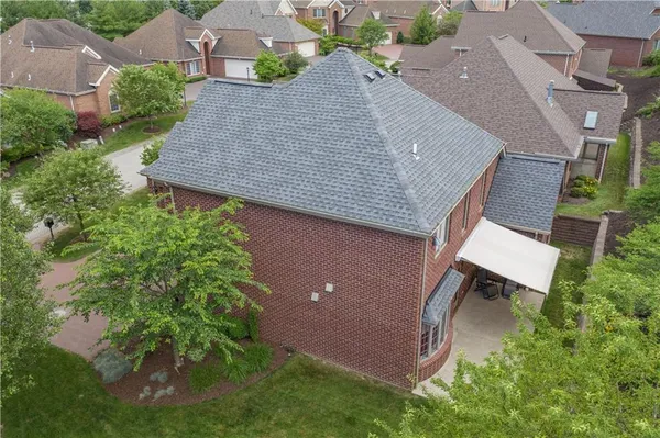 an aerial view of a house with a yard and trees all around