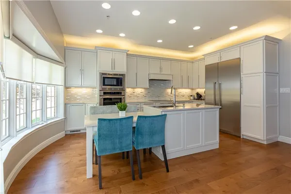 a kitchen with kitchen island granite countertop a stove a sink a refrigerator and a refrigerator