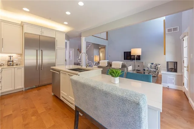 a kitchen with stainless steel appliances kitchen island granite countertop a refrigerator a stove and a sink with granite countertops