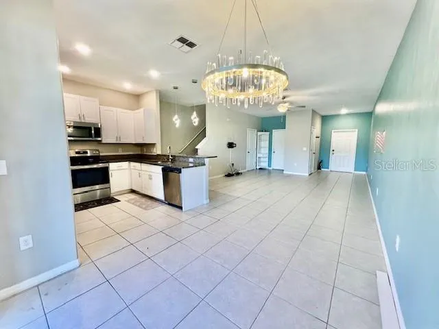 a kitchen with stainless steel appliances granite countertop a refrigerator a stove and a sink