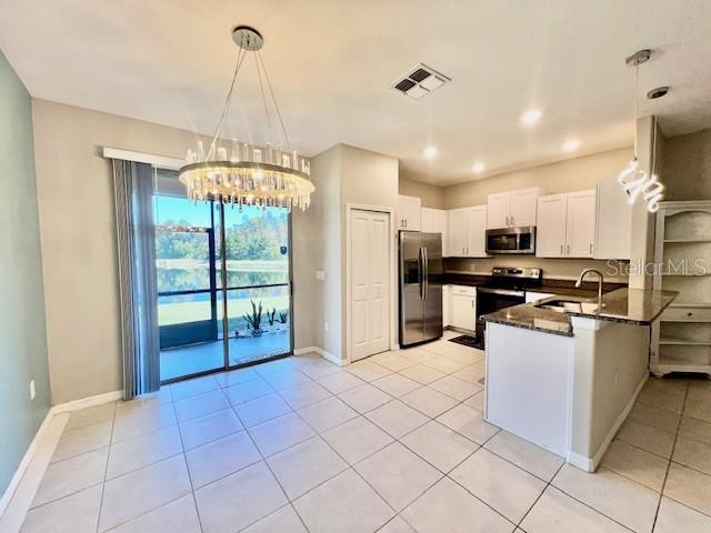 8606 Reedville Street New Port Richey, FL 34654 - Photo 13 of 85 a kitchen with stainless steel appliances granite countertop a refrigerator and a stove top oven