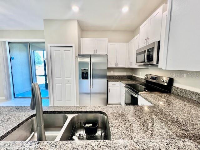8606 Reedville Street New Port Richey, FL 34654 - Photo 19 of 85 a kitchen with stainless steel appliances granite countertop a refrigerator a stove and a sink