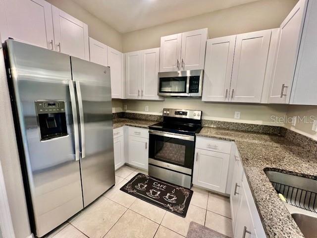 8606 Reedville Street New Port Richey, FL 34654 - Photo 22 of 85 a kitchen with stainless steel appliances granite countertop a stove a refrigerator and a sink