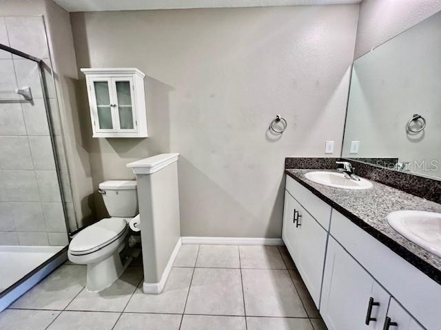 8606 Reedville Street New Port Richey, FL 34654 - Photo 32 of 85 a bathroom with a granite countertop sink toilet and mirror