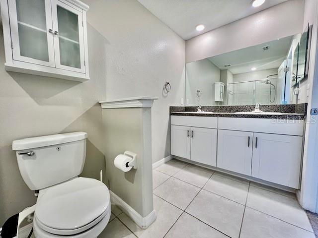 8606 Reedville Street New Port Richey, FL 34654 - Photo 33 of 85 a bathroom with a granite countertop toilet sink and mirror