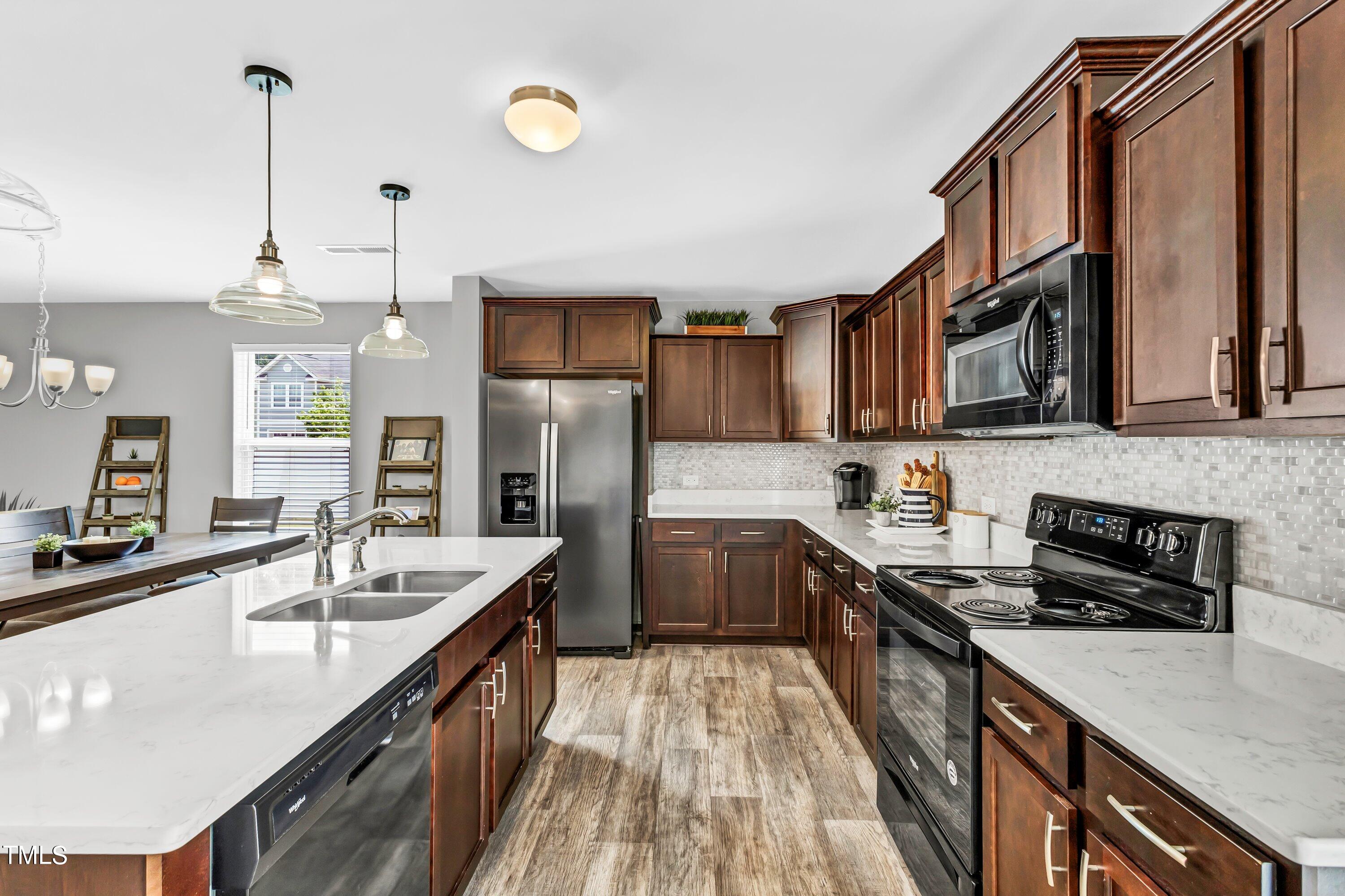 301 Connect Drive Wendell, NC 27591 - Photo 11 of 28 a kitchen with stainless steel appliances granite countertop a sink a stove and a refrigerator