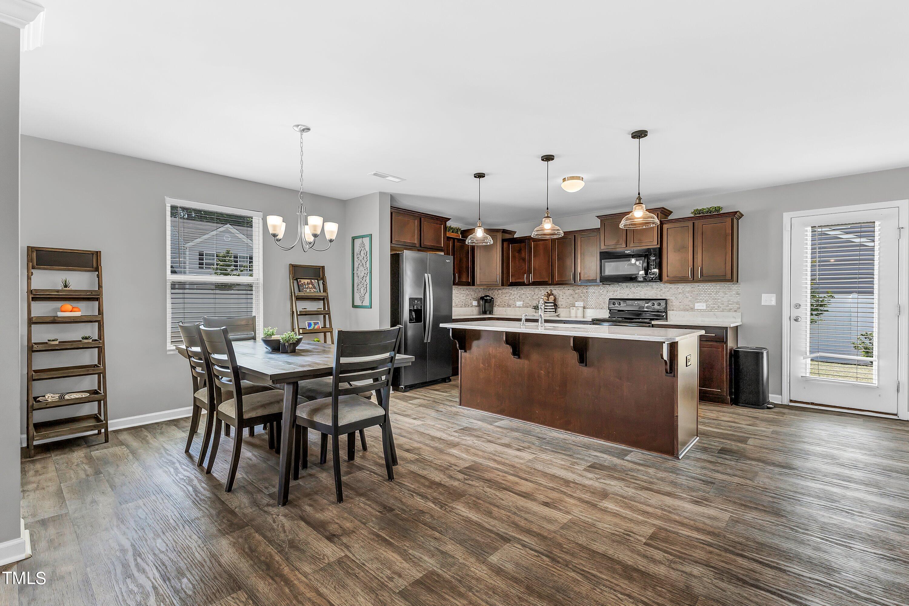 301 Connect Drive Wendell, NC 27591 - Photo 8 of 28 a kitchen with stainless steel appliances kitchen island granite countertop a table chairs and a refrigerator