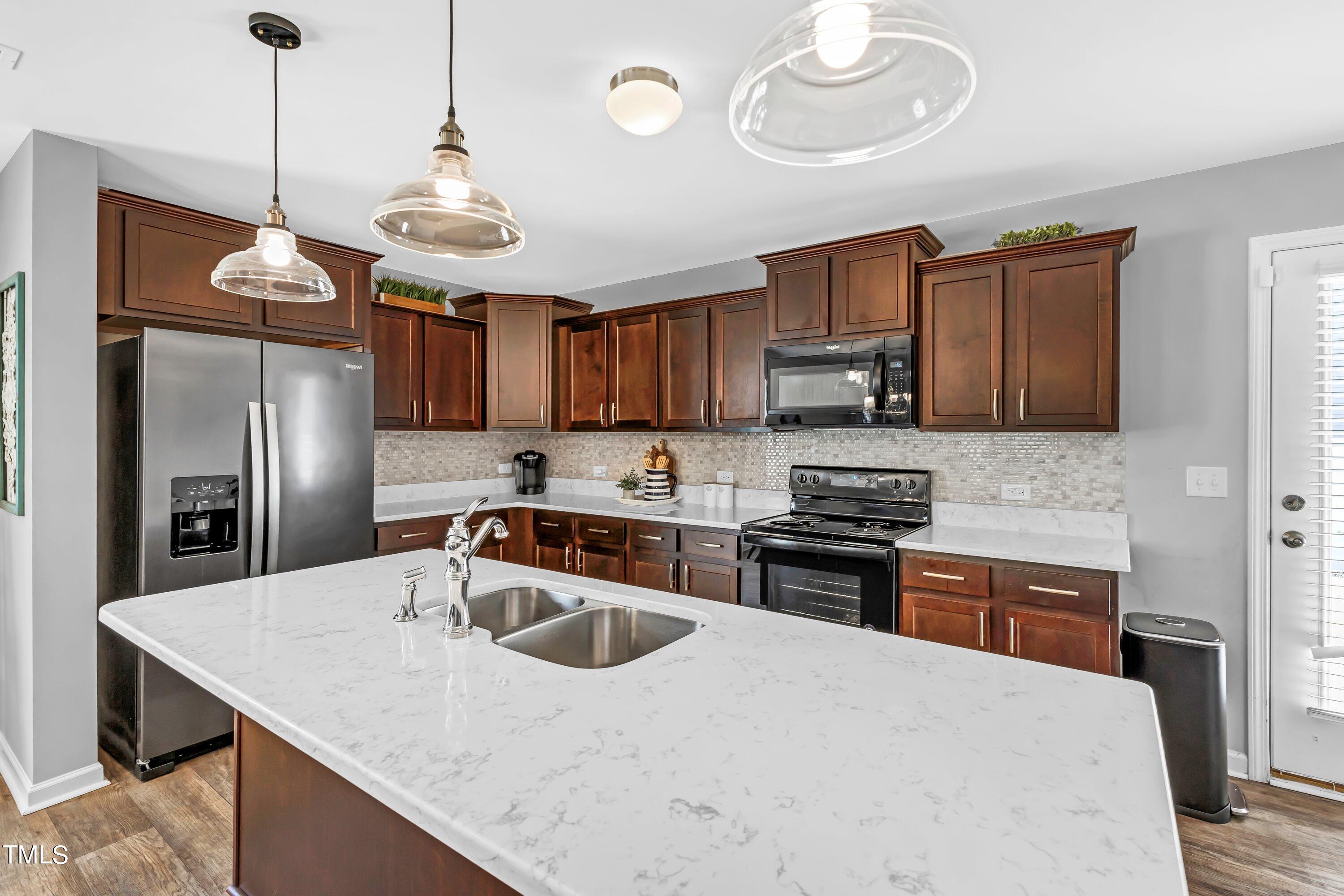 301 Connect Drive Wendell, NC 27591 - Photo 9 of 28 a kitchen with stainless steel appliances granite countertop a sink a stove a refrigerator cabinets and chairs