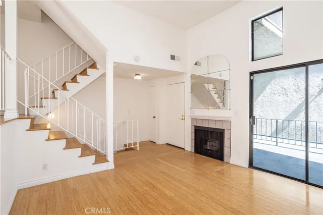 a view of an entryway with wooden floor and a fireplace