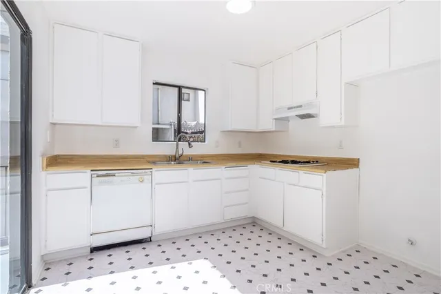 a kitchen with granite countertop white cabinets and white appliances