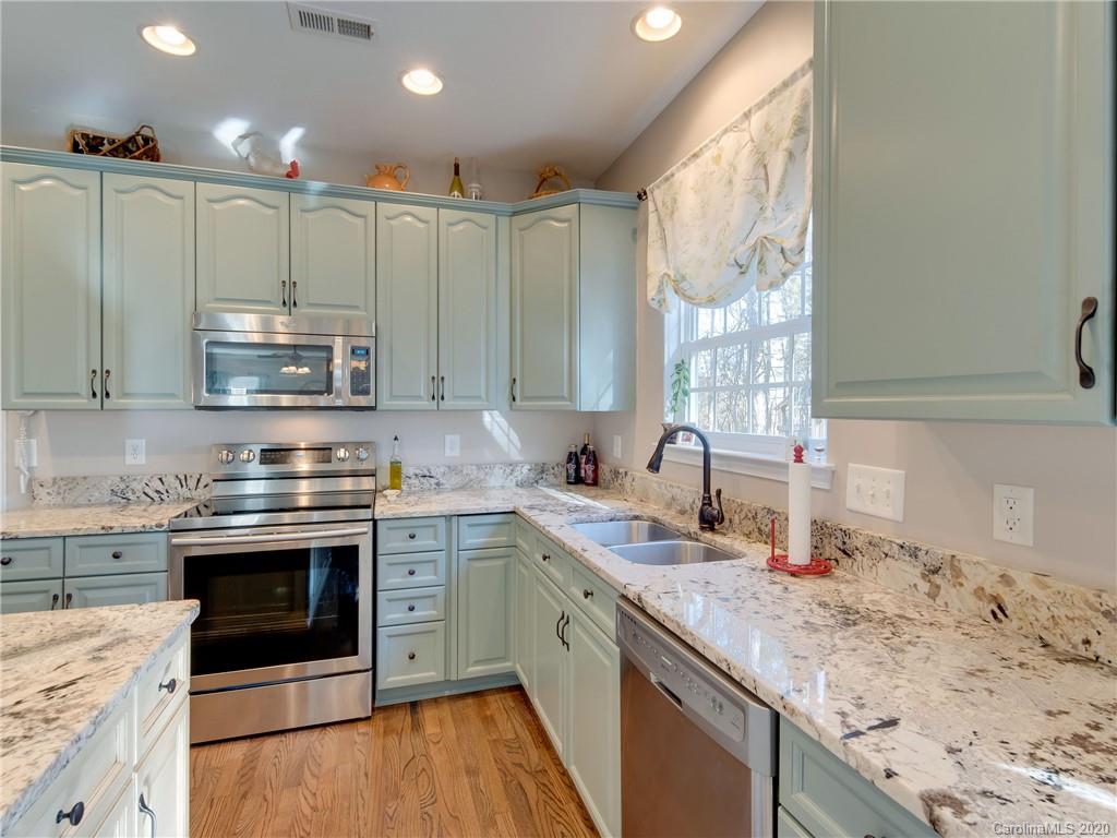 3028 Strawberry Road Matthews, NC 28104 - Photo 11 of 44 a kitchen with stainless steel appliances granite countertop a sink stove and cabinets