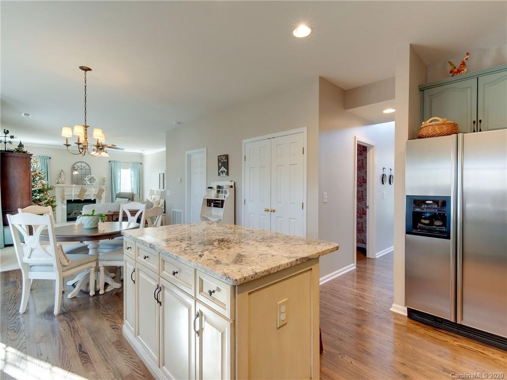 3028 Strawberry Road Matthews, NC 28104 - Photo 12 of 44 a view of a kitchen island a dining table wooden floor and a view of living room