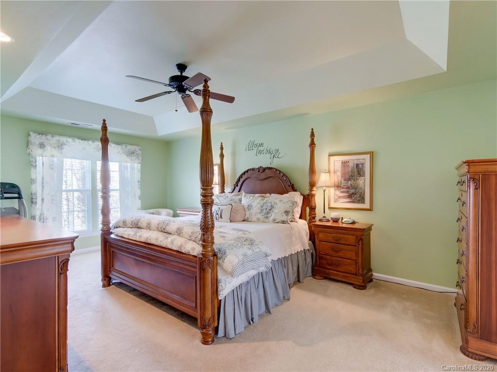 3028 Strawberry Road Matthews, NC 28104 - Photo 26 of 44 a bedroom with a bed and a chandelier