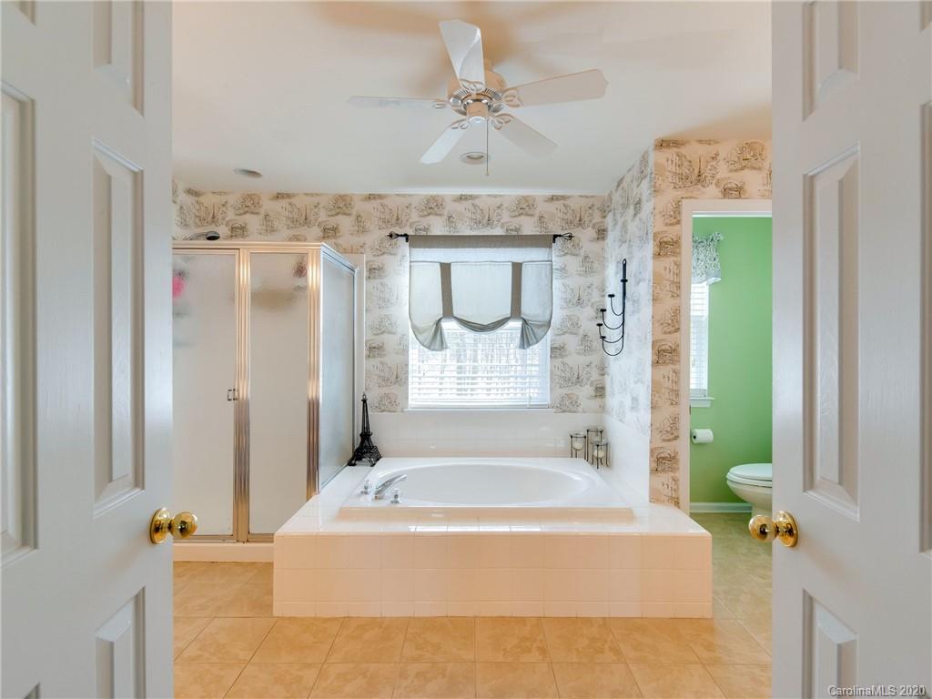 3028 Strawberry Road Matthews, NC 28104 - Photo 27 of 44 a bathroom with a bathtub a sink and a shower