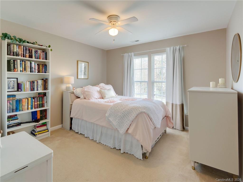 3028 Strawberry Road Matthews, NC 28104 - Photo 30 of 44 a bedroom with bed and a chandelier