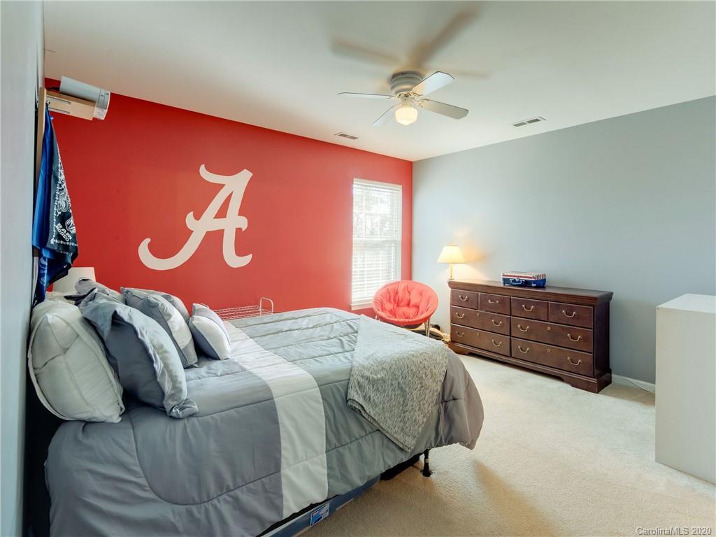 3028 Strawberry Road Matthews, NC 28104 - Photo 32 of 44 a bedroom with a bed and a chandelier