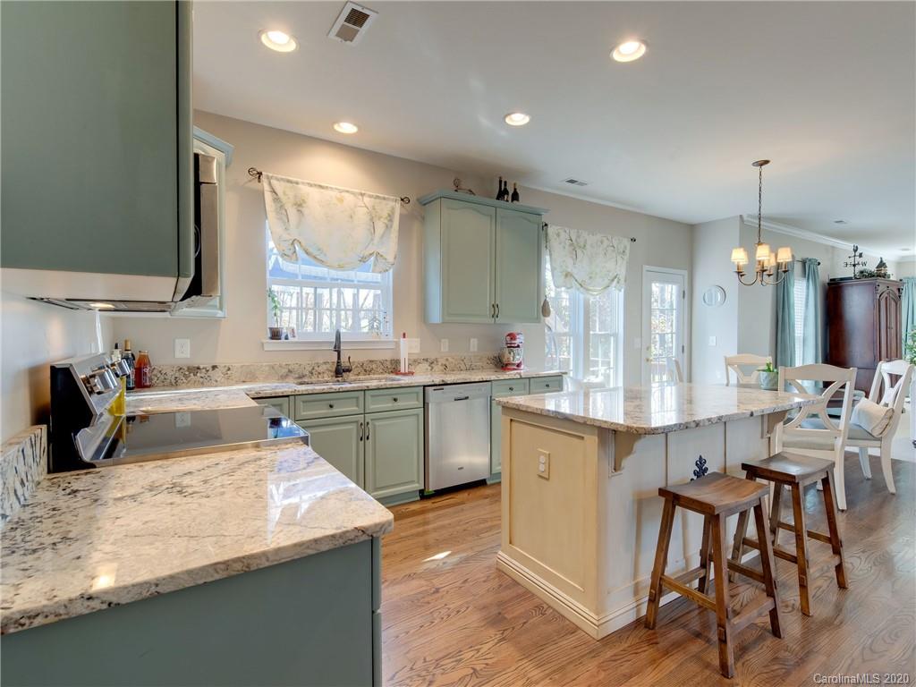 3028 Strawberry Road Matthews, NC 28104 - Photo 7 of 44 a kitchen with a sink stove and wooden cabinets