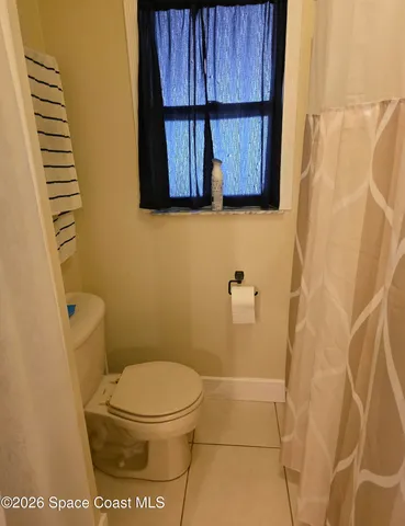 a bathroom with a toilet and a shower curtain