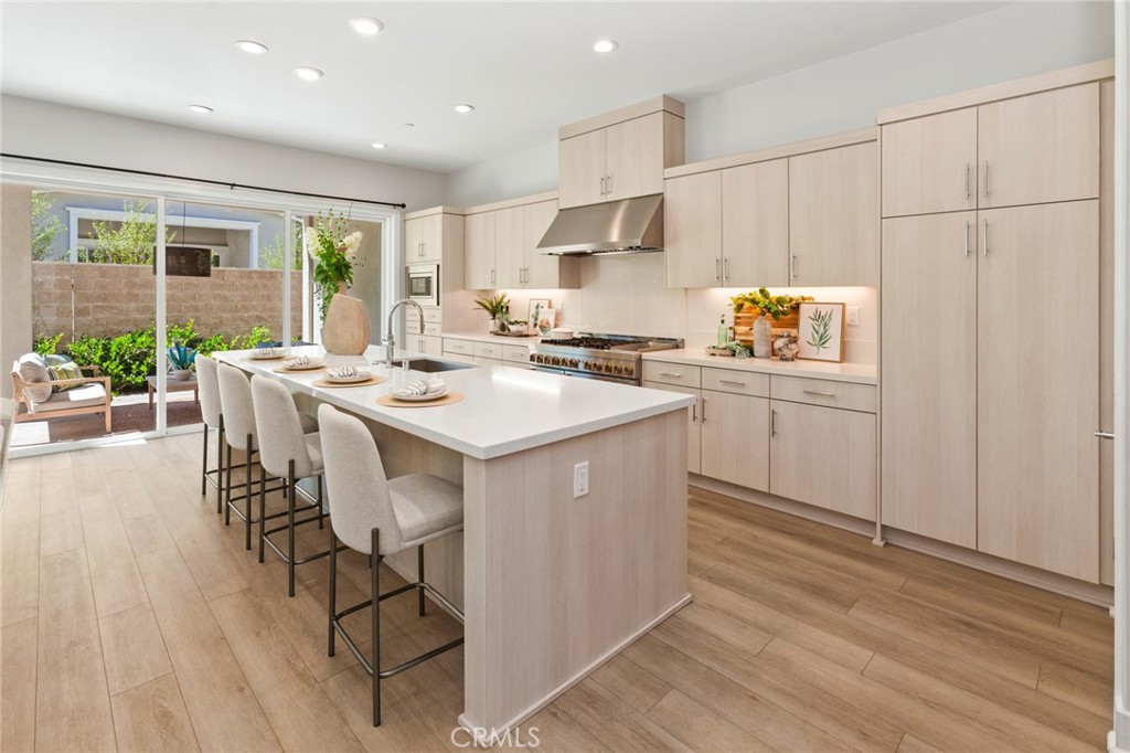 181 Mulberry Lake Forest, CA 92630 - Photo 9 of 46 a kitchen with stainless steel appliances kitchen island granite countertop a stove a sink a refrigerator and white cabinets with wooden floor